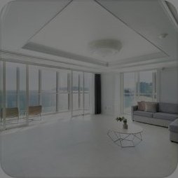 해운대 팔레드시즈 — 바다가 보이는 통유리창, 회색 소파와 유리 테이블이 놓인 밝은 흰색 레지던스 거실
