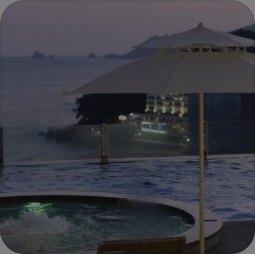 해운대 베이몬드 호텔 — 해질녘 루프탑 인피니티 풀과 원형 자쿠지, 흰 파라솔, 뒤로 바다와 바위섬