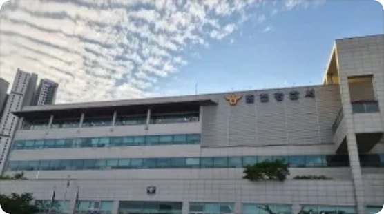 파란 하늘과 잔물결 구름 아래 촬영한 지방 경찰서 청사 외관, 건물 상단에 금색 참수리 휘장과 관서명 현판이 붙어 있다