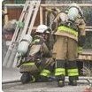 防火服と空気呼吸器を着用しはしごの横に立つ消防隊員2人